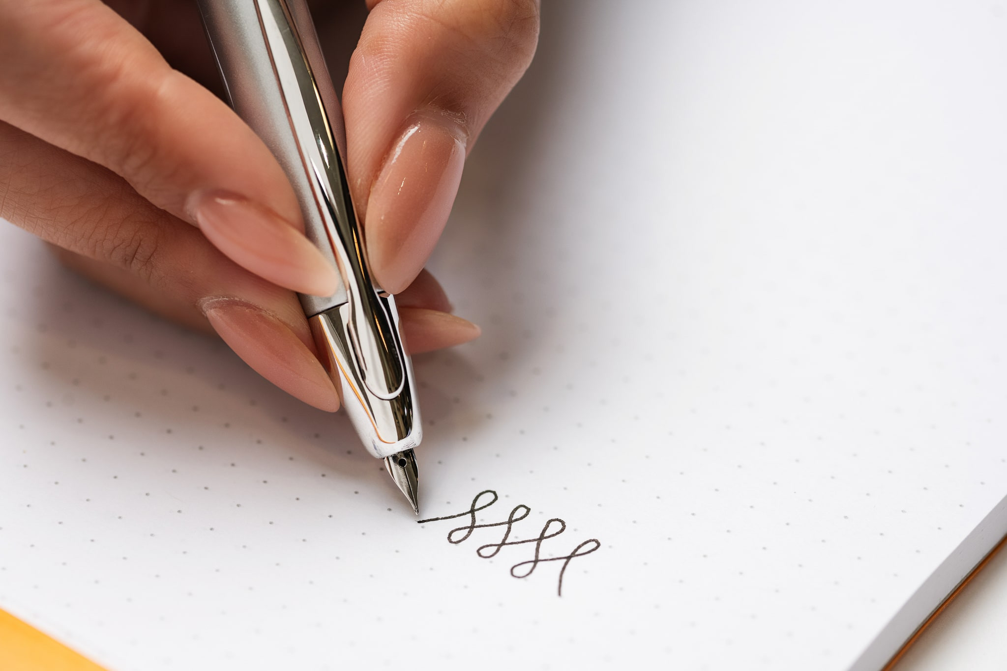 A close of view of the Tripod Pen Hold technique used for fountain pen calligraphy.