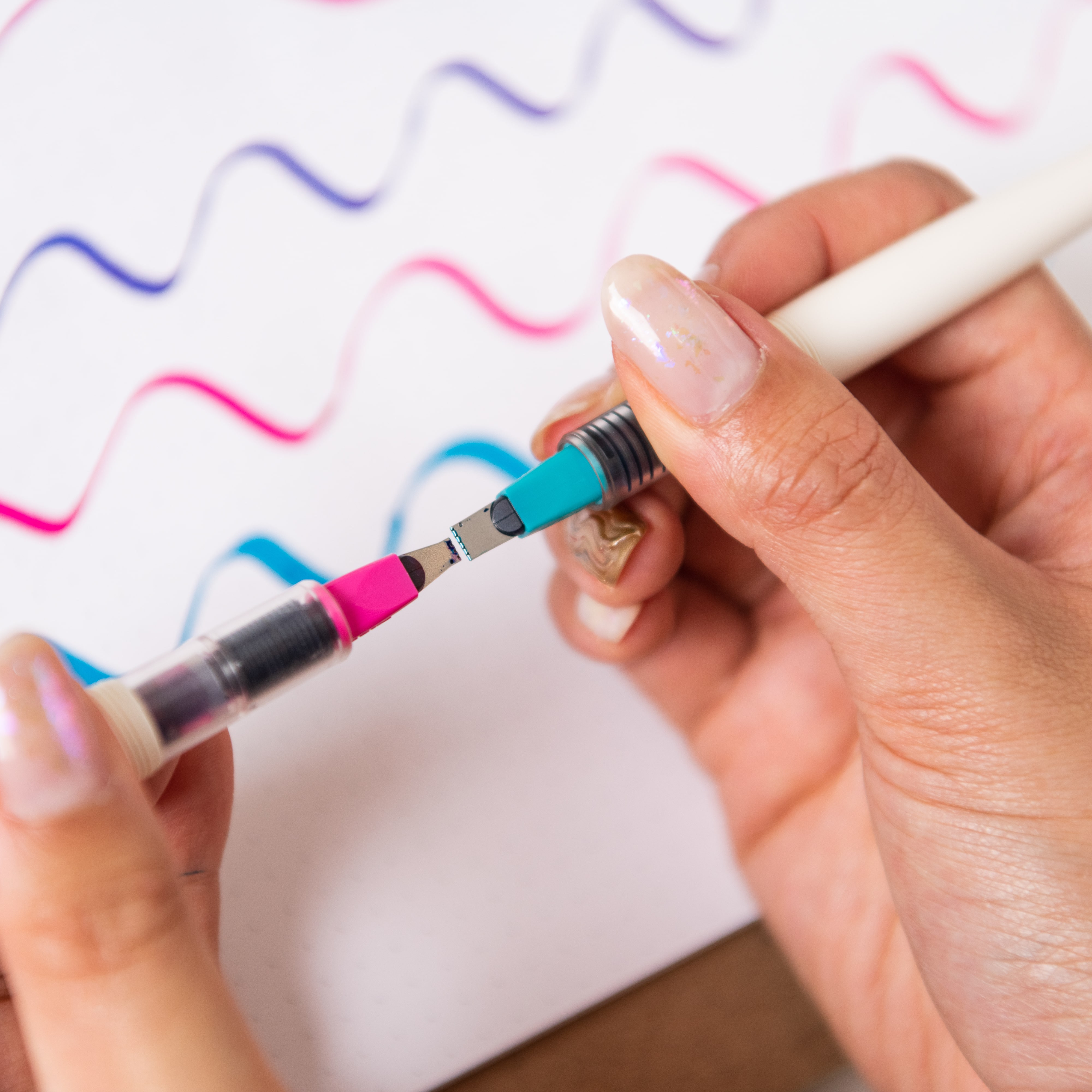 A woman comparing the nib sizes of two Parrel Pens.