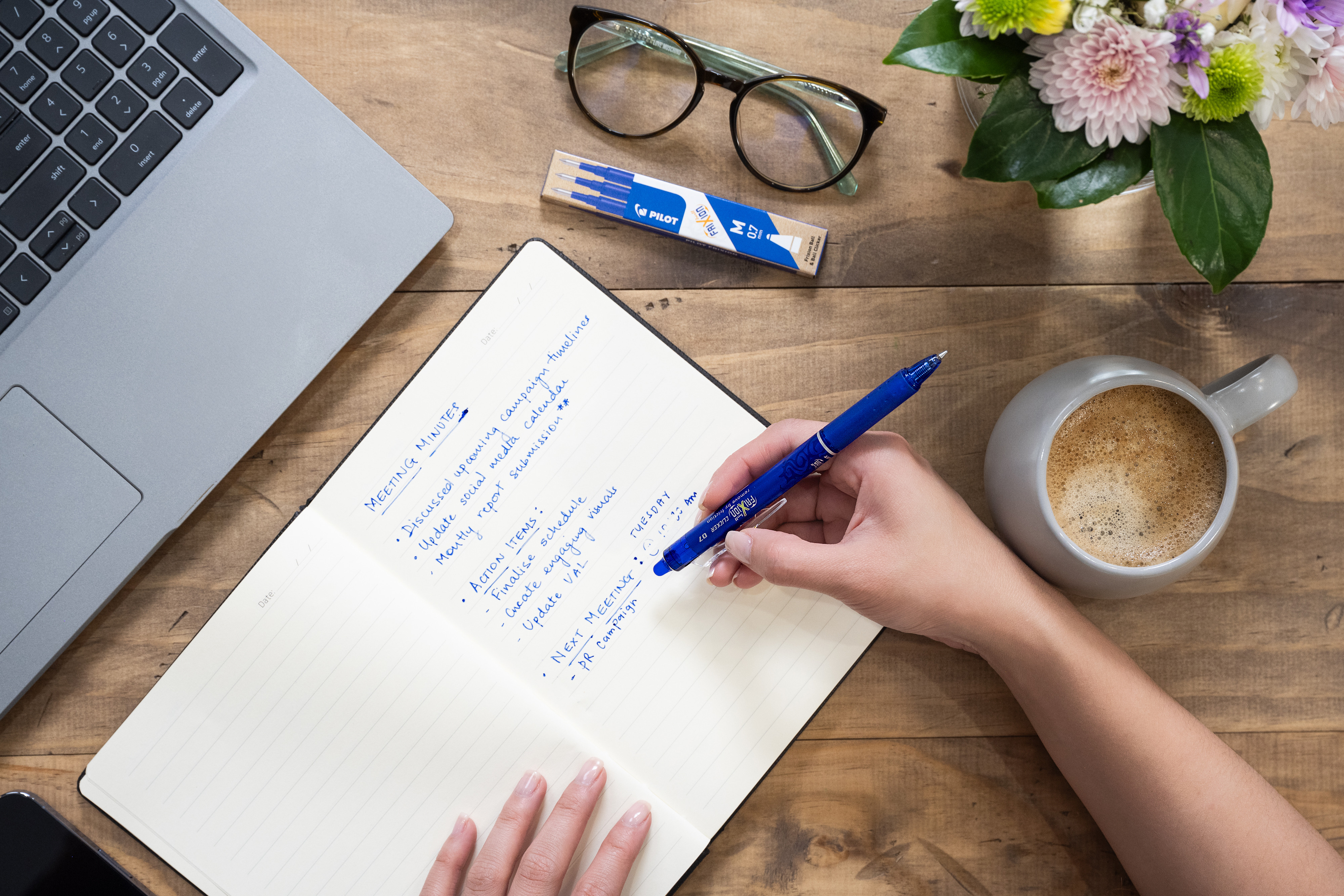 Hand holding a FriXion Clicker Erasable Gel Pen, writing a to-do list in a notebook, a practical tool for organised and error-free everyday use.