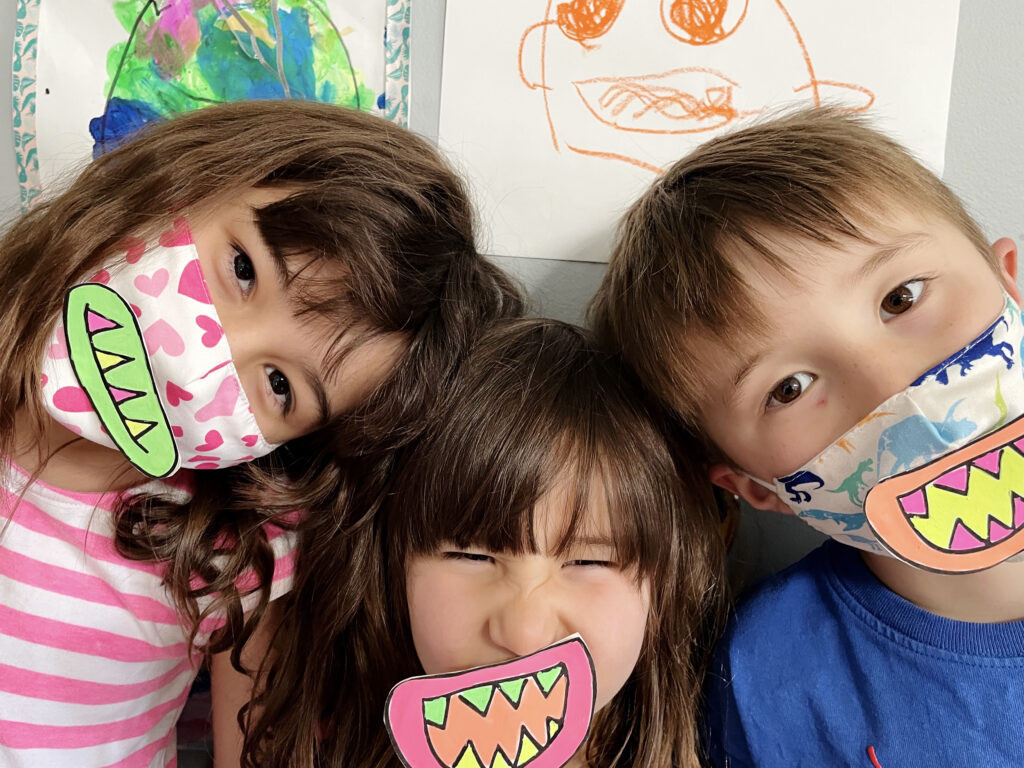 3 Happy Children show off the face masks they've made for Halloween